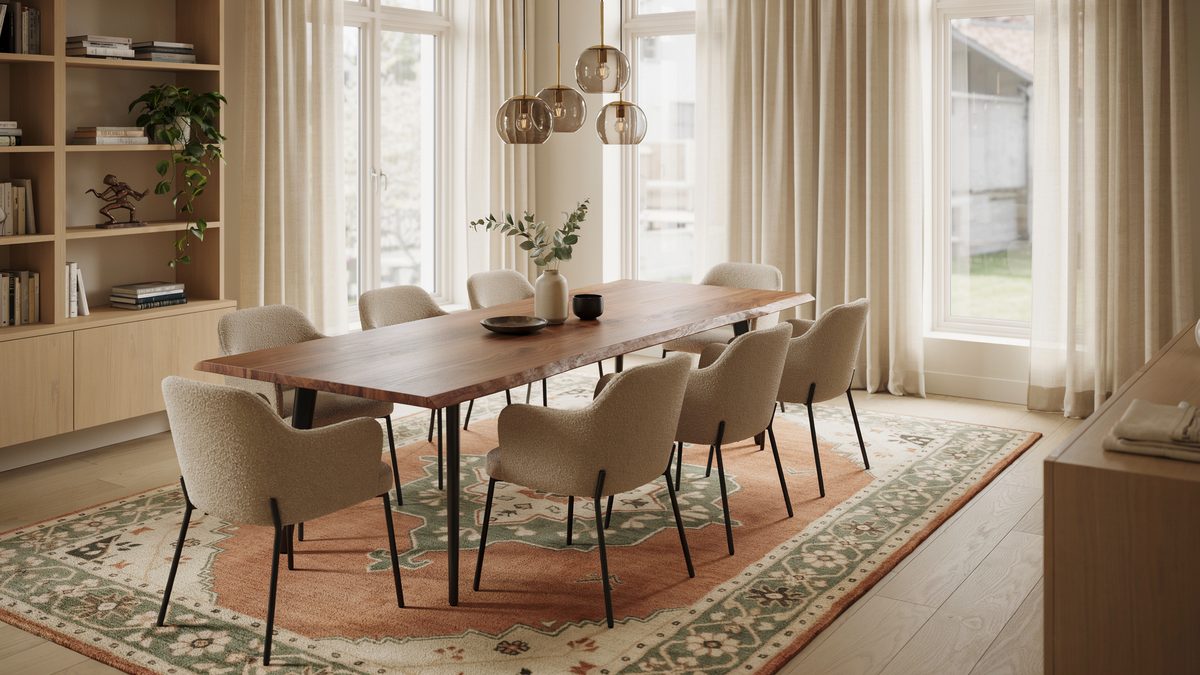 Walnut dining table with eight boucle chairs sitting on a green and rust bordered rug