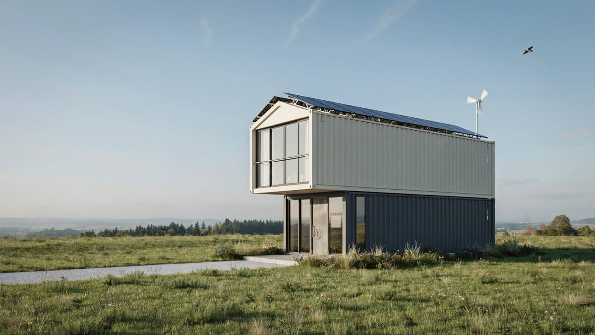 Two story container house with rooftop solar panels and a small wind turbine