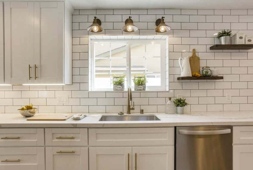 Kitchen sink window with sconce lighting subway tile wall white cabinets