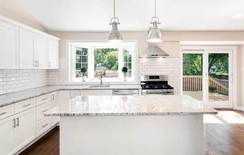 Kitchen with bay window, silver pendants and white cupboards