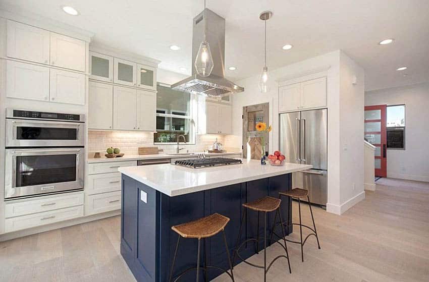 Kitchen with ceiling mounted range hood blue island and white cabinets