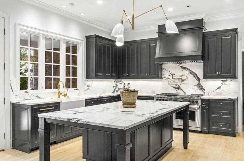 Kitchen with colonial grid design windows, dark cabinetry and quartz slab counters