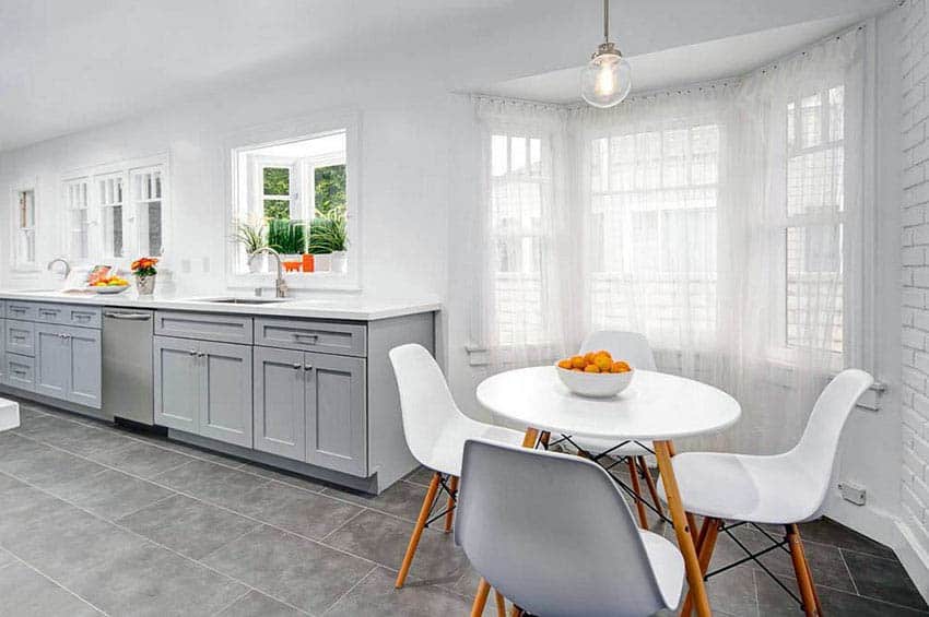 Kitchen with gray cabinets, small dining nook and drapery windows