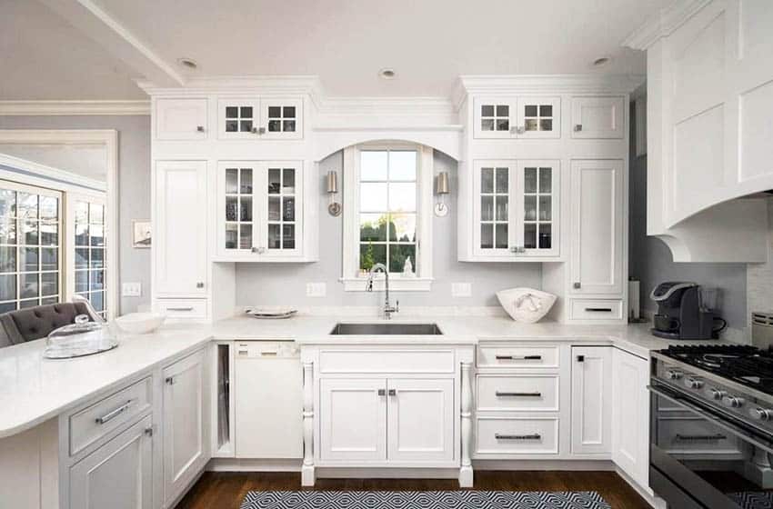 Kitchen with window over sink white cabinets with glass doors