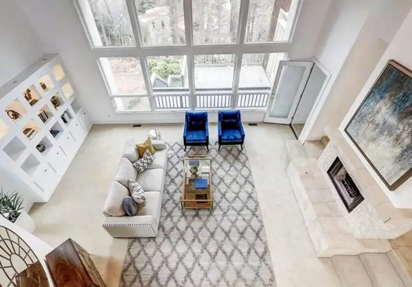 An aerial view of a room with white cabinets, grey rug and couch