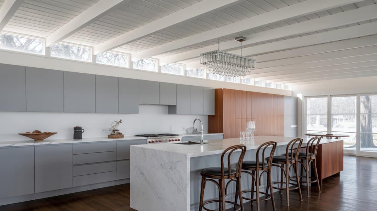 Mid-century modern kitchen with white painted tongue and groove ceiling and clerestory windows above gray flat-front cabinets