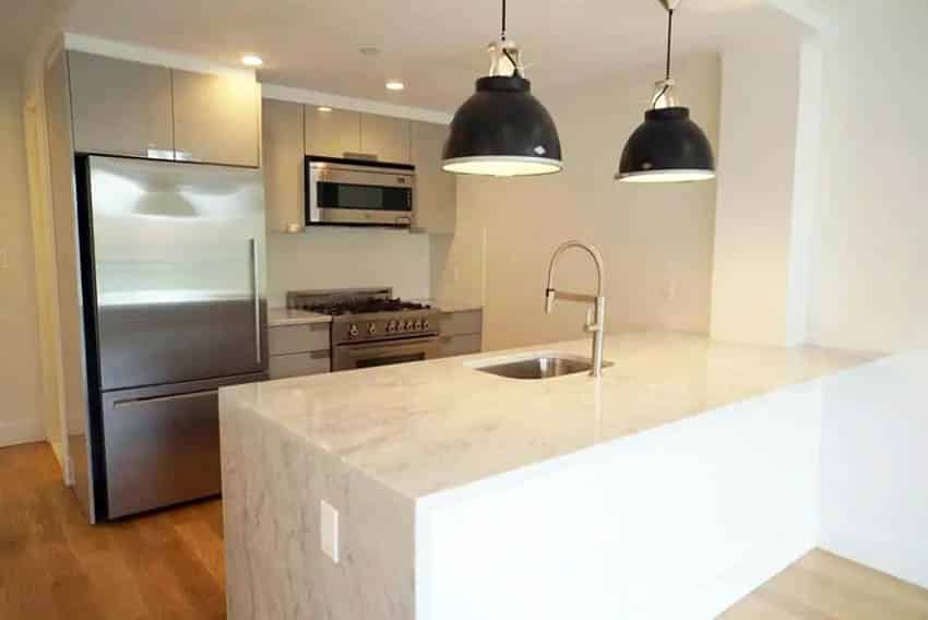 modern-kitchen-with-beige-gloss-cabinets-quartz-waterfall-counter-peninsula