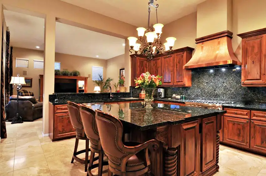Rustic kitchen with custom copper range hood, solid wood cabinets and black granite counters