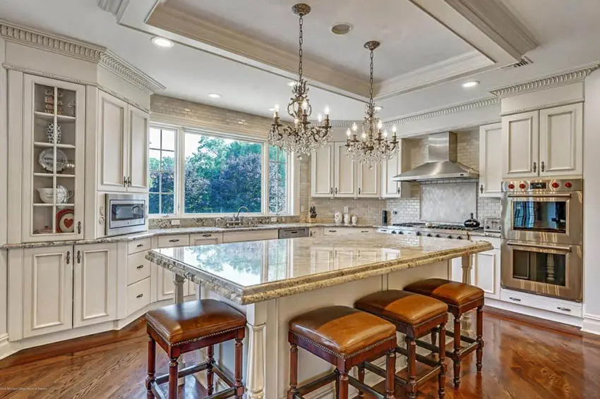 traditional-kitchen-with-beige-cabinets-yellow-granite-island-chandeliers
