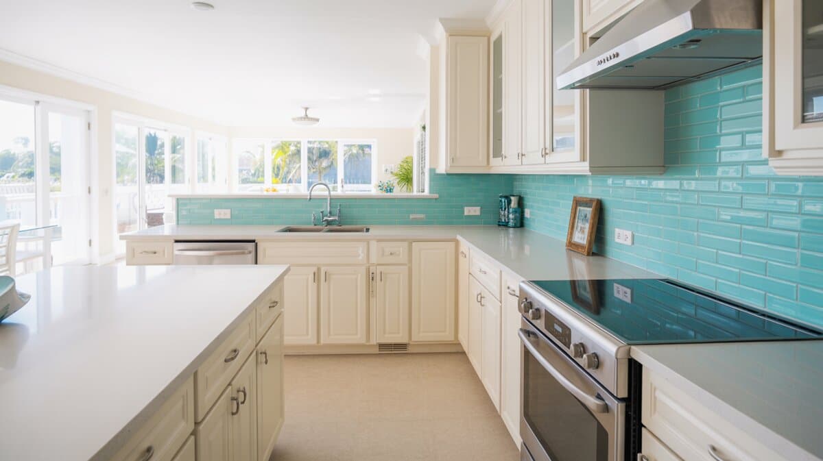 Cream cabinet kitchen with arctic white quartz and bright aqua glass backsplash
