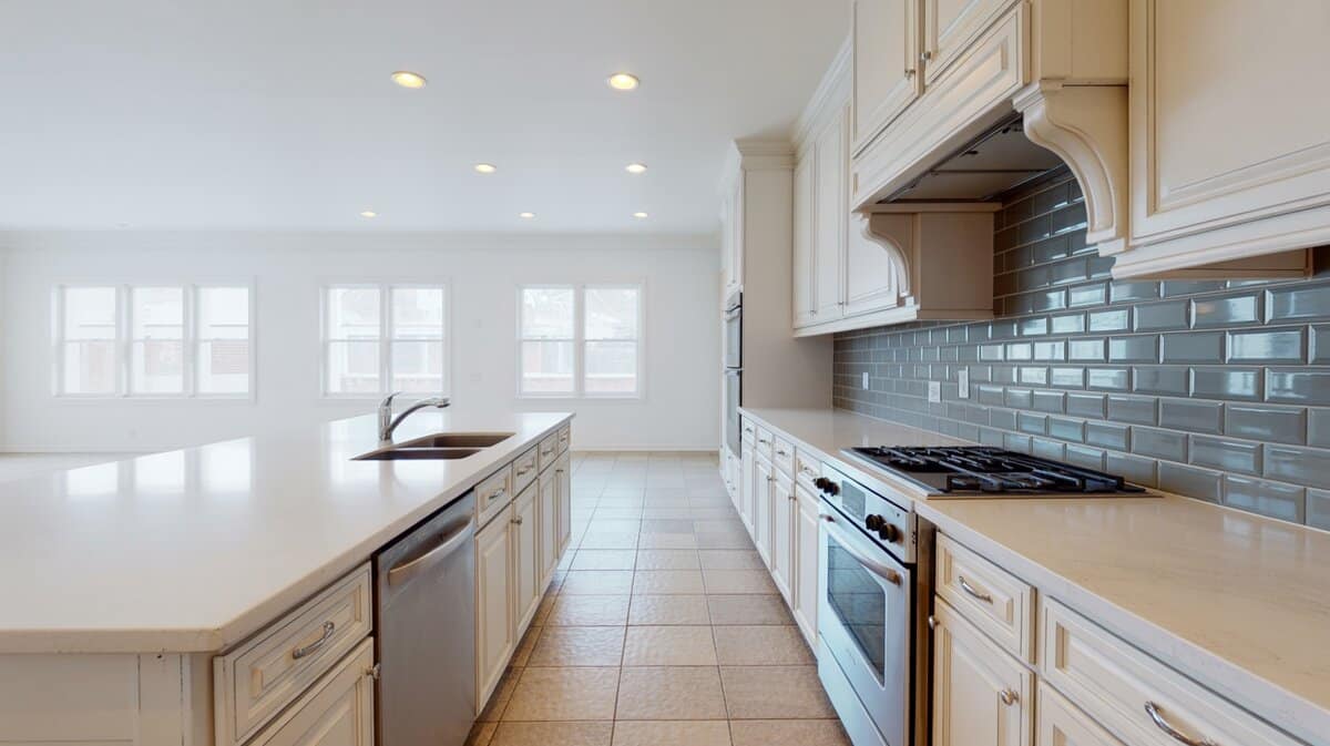 All white kitchen with white quartz and soft gray subway tile backsplash