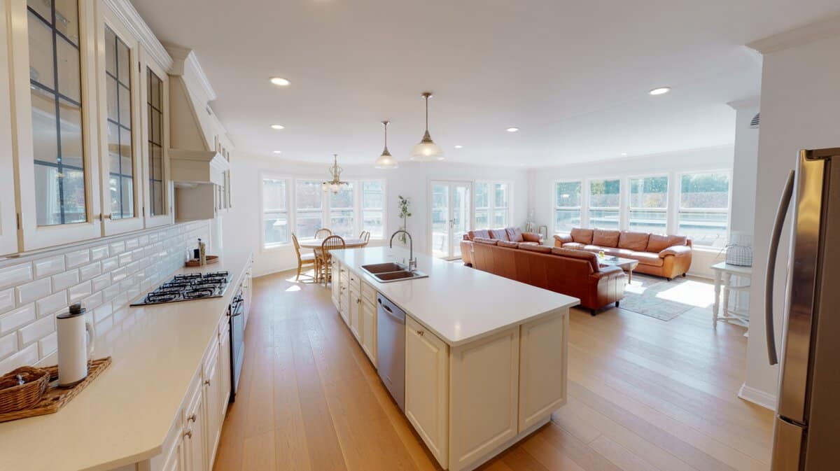 Open layout white kitchen with super white quartz opening to a living area
