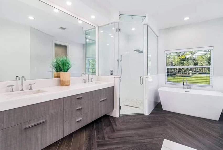 Bathroom with dual sinks, shower area and white tub