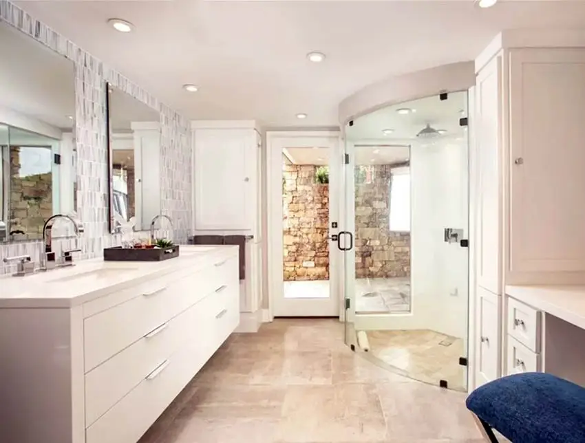 Curved glass shower door, marble backsplash and recessed lighting