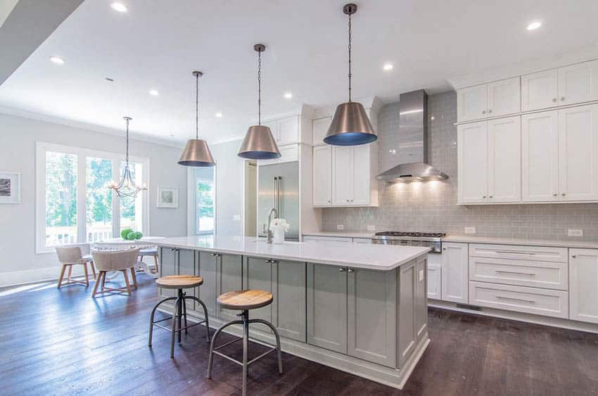 Kitchen with dark wood flooring and light gray walls with white cabinets gray island