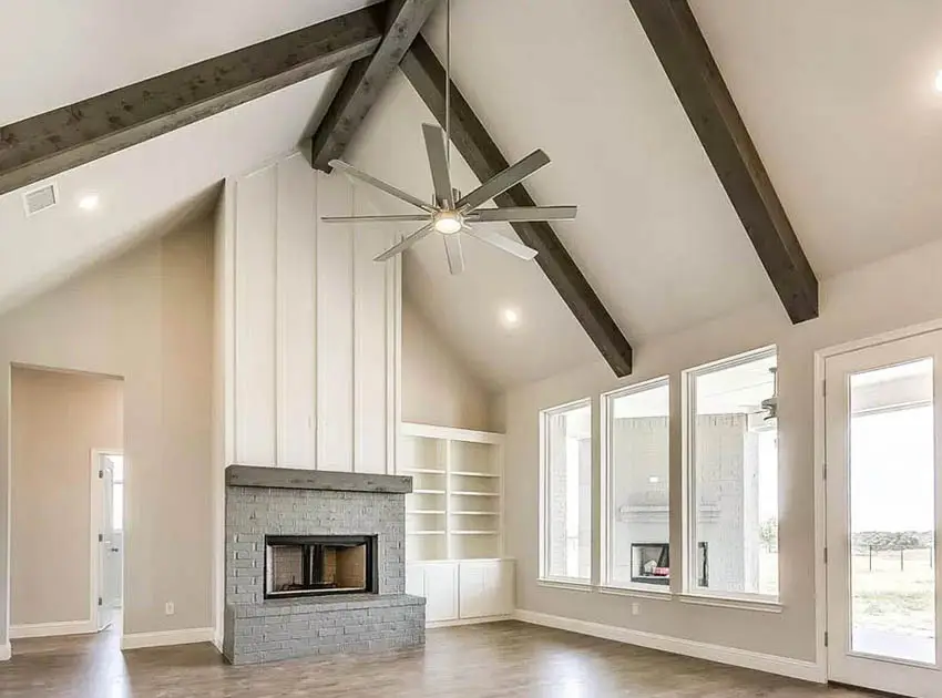 Living room with vaulted ceiling wood beams recessed lighting and hanging fan