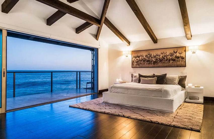 Luxury bedroom with overhead beams and ocean views with giant slider