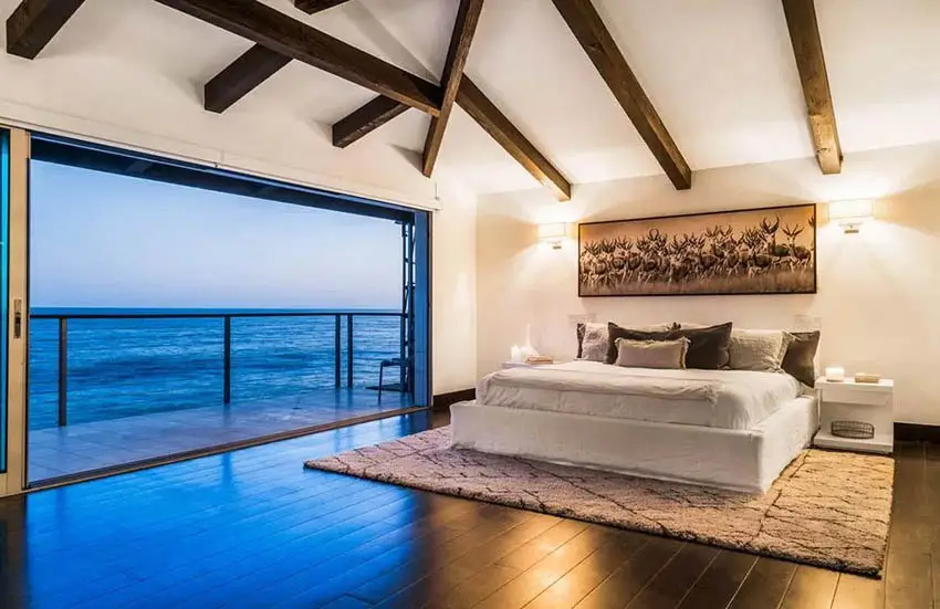 Luxury bedroom with wood vaulted ceiling ocean views