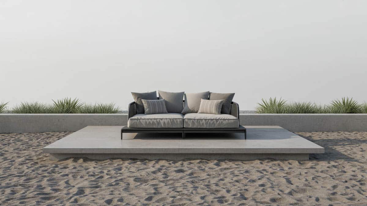 Raised concrete patio with coarse gray sand ground cover and an outdoor daybed lounge chair