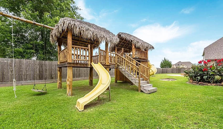 Backyard playground with thatched palapa roof