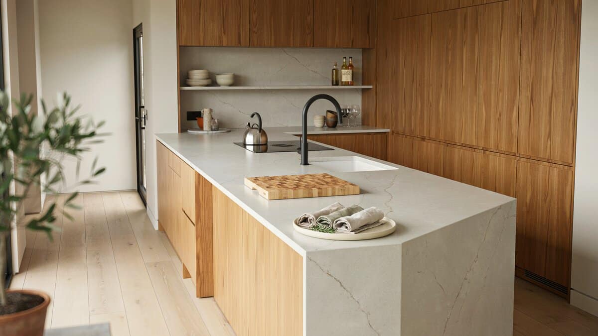 Cutting board and rolled napkins on white quartz counters with veneer cabinets
