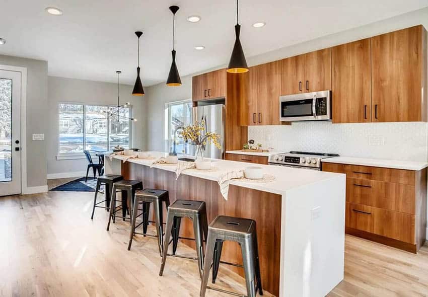 Kitchen with veneer cabinets, white quartz countertops, place settings and cutting board