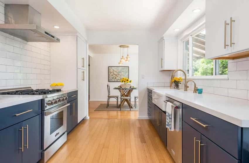 Cute galley kitchen with blue white cabinets fresh flowers and fruit