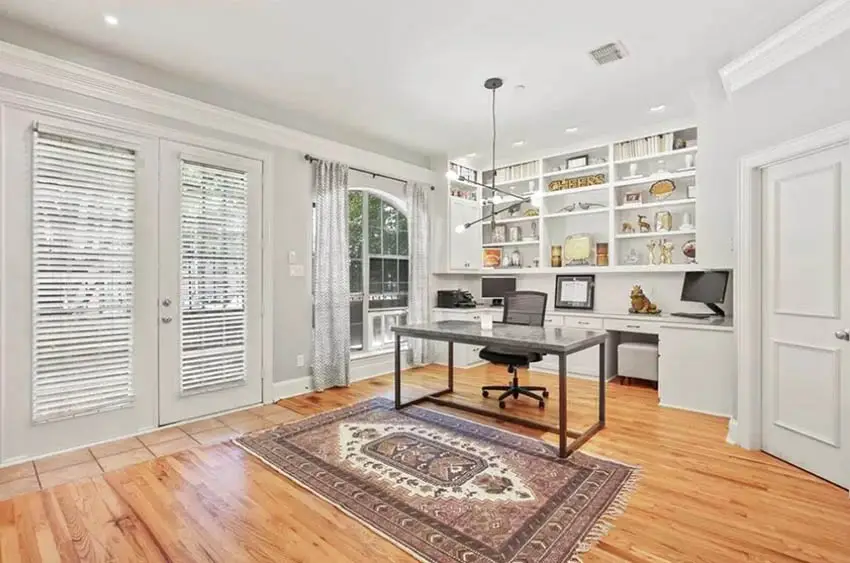 Office with two-panel doors, shelves behind the office desk and minimalist lighting fixture