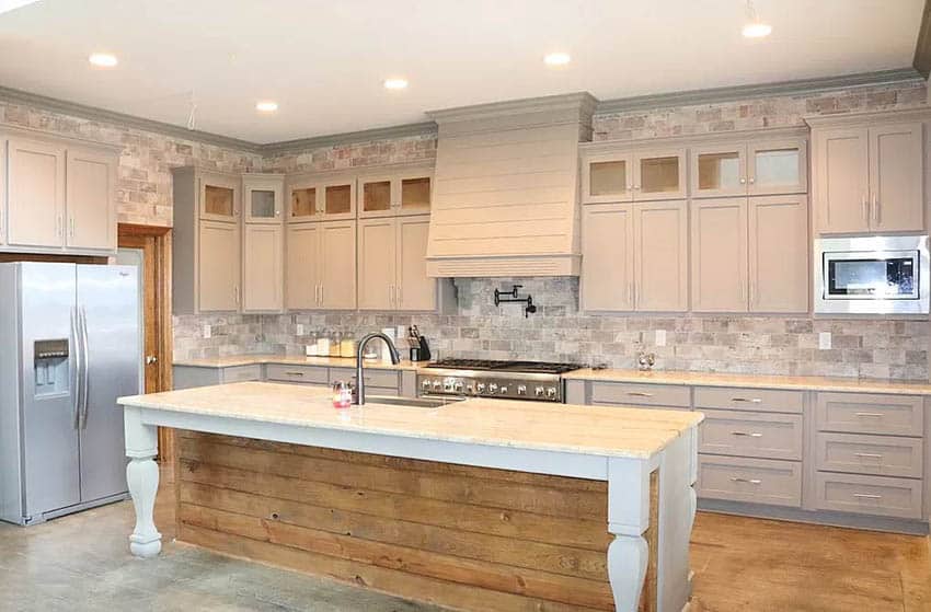 Kitchen with large rustic wood island with white legs gray cabinets