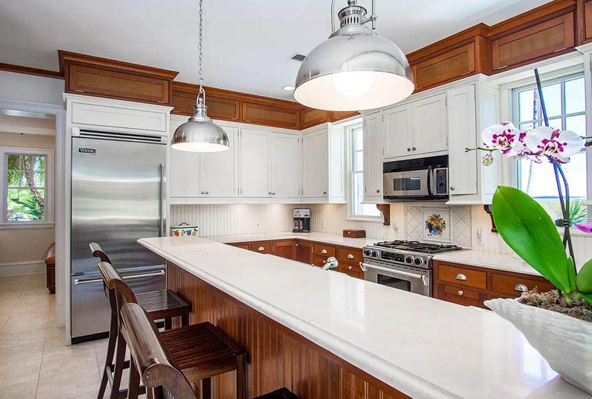 U-shaped kitchen with silver drum ceiling lights and bar stools