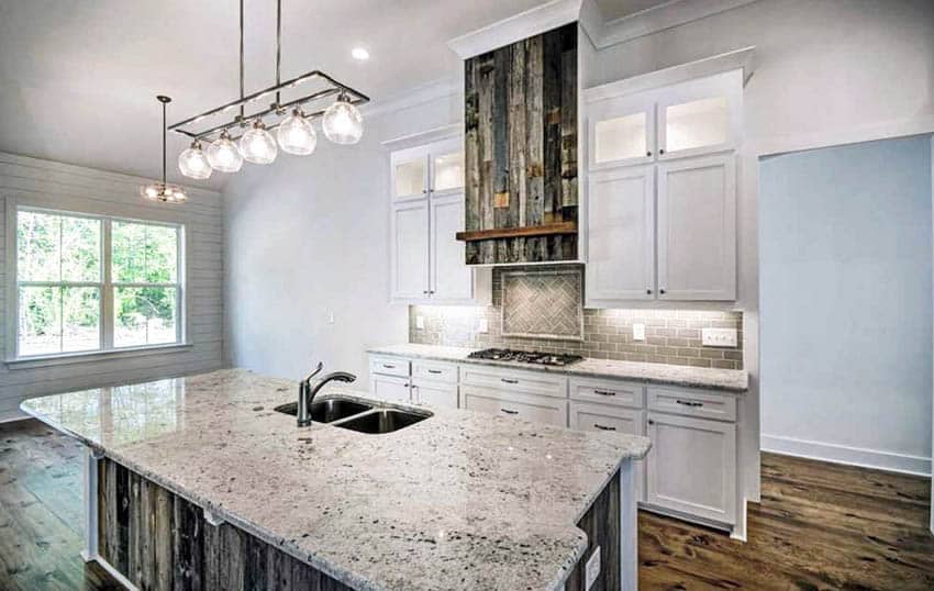 Kitchen with reclaimed wood island and oven hood with white granite countertops