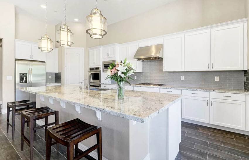 Kitchen with granite counters, grey backsplash and fresh flowers