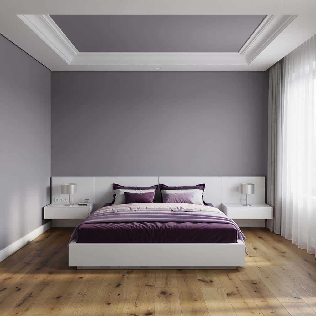 Bedroom with a shallow ceiling, lavender-painted walls and white furniture.