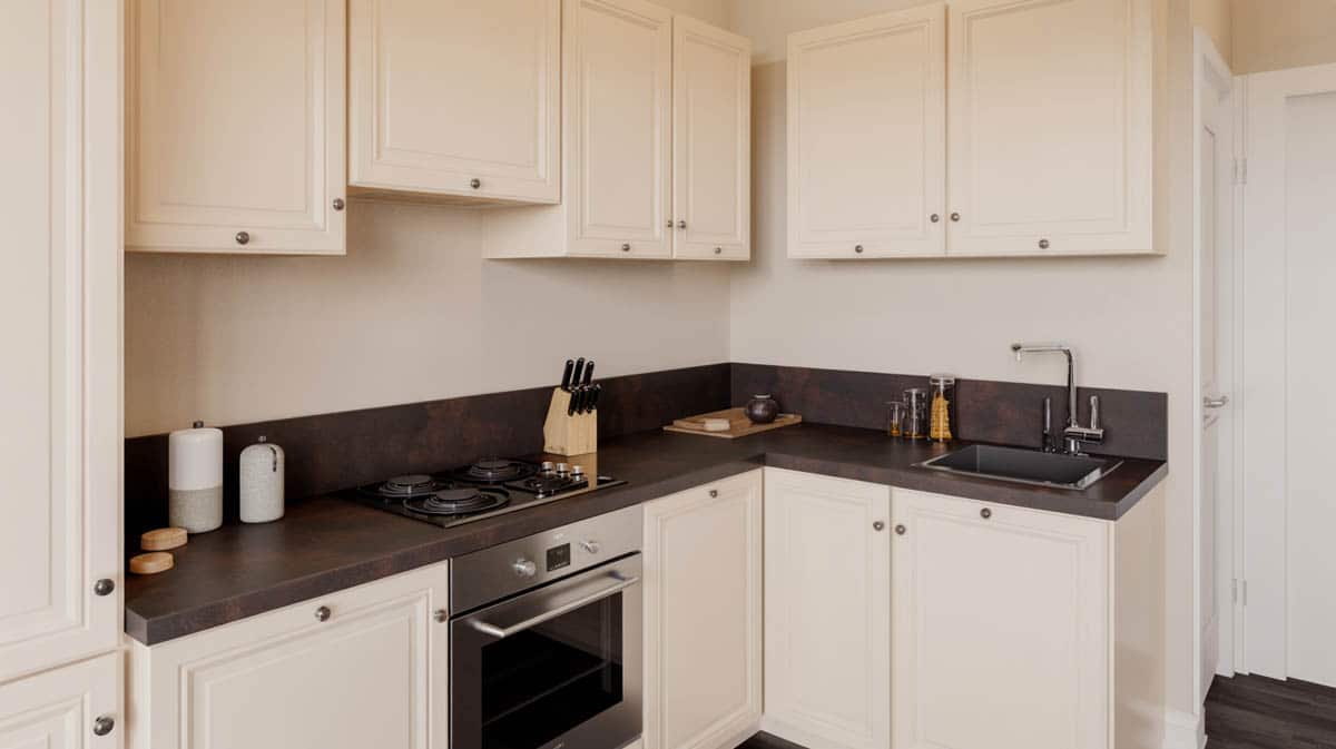 Small compact kitchen with dark beige quartz countertop and white cabinetry