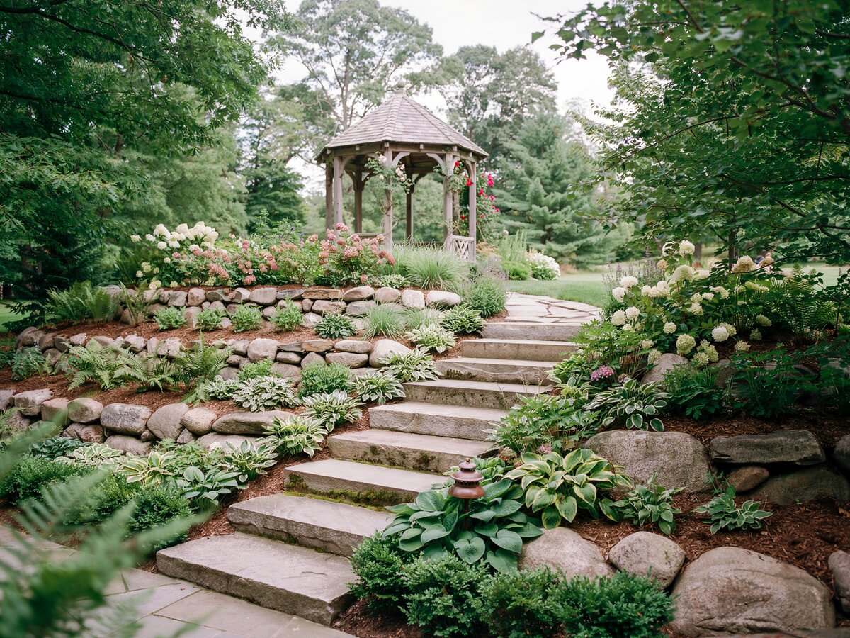 Multi-level terraced rock garden with granite slab steps stone retaining walls and a garden gazebo