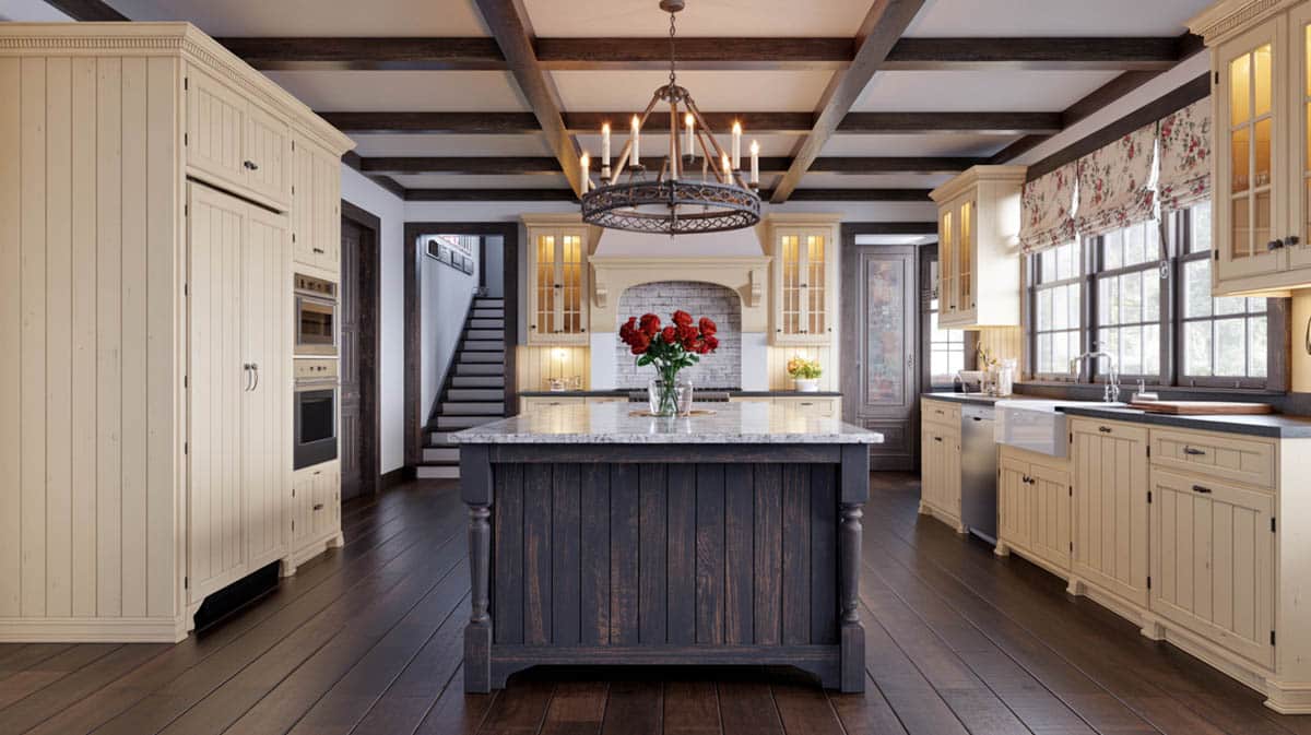 Cream antique cabinets with a dark charcoal island, brass chandelier, and dark coffered beam ceiling