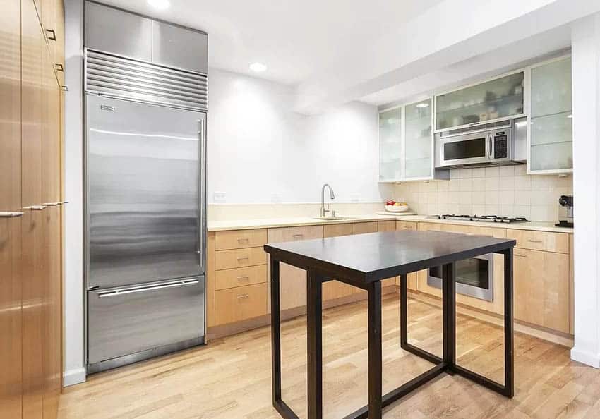 Kitchen with industrial type refrigerator and small table with black legs