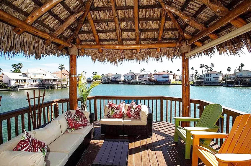 Waterfront backyard palapa with outdoor furniture