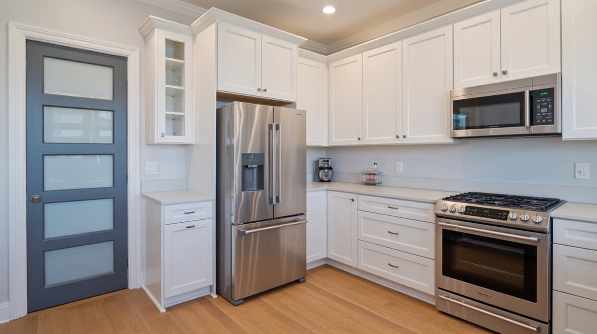White kitchen with blue frosted glass pantry door and stainless steel appliances