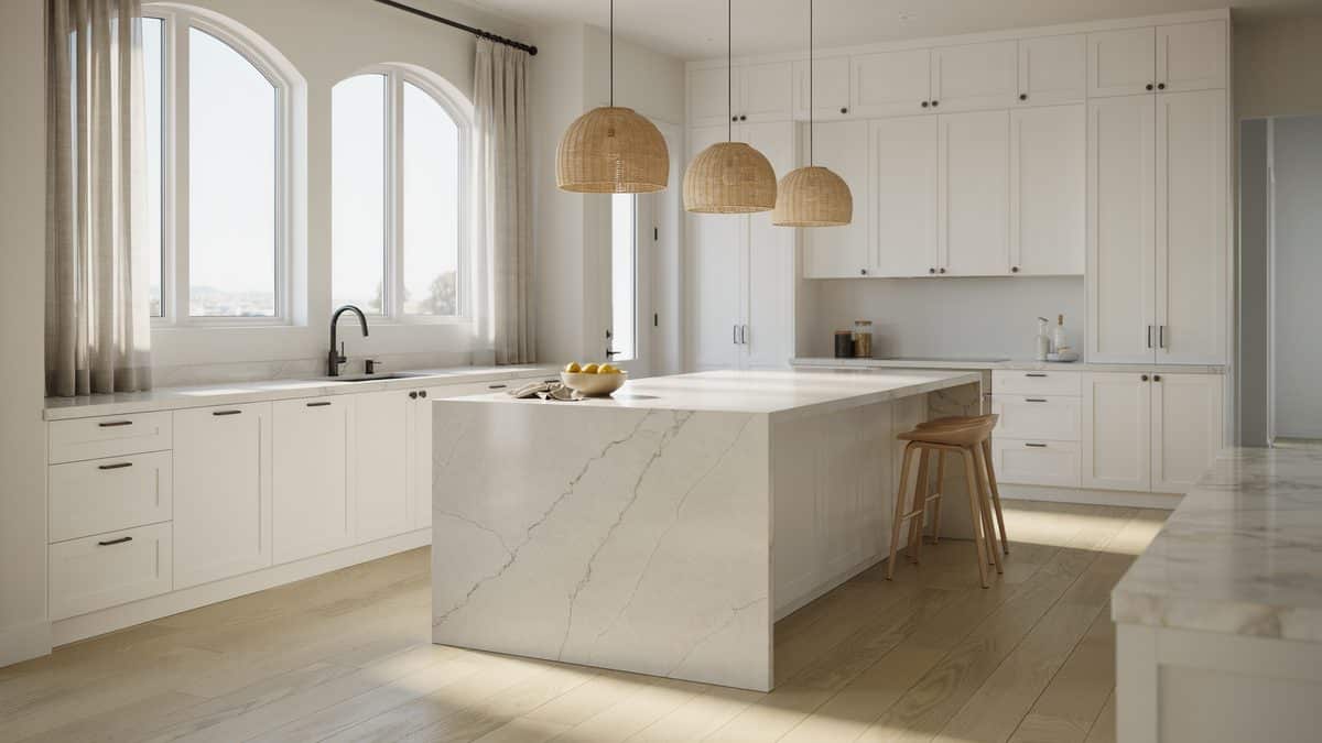 Airy white kitchen with rattan pendants above a veined waterfall porcelain island