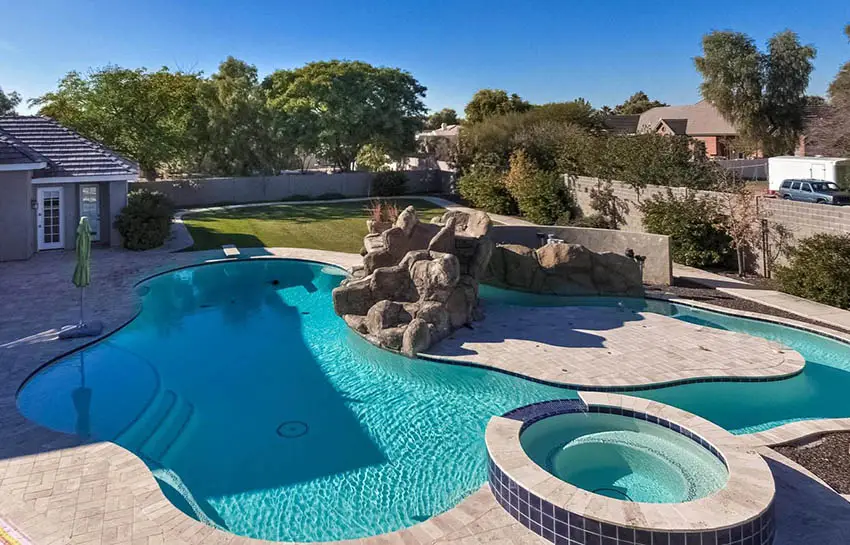 Backyard lazy river pool with rock water feature