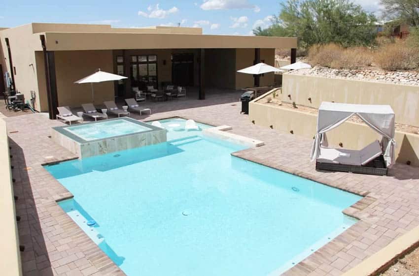 Backyard pool with sloped yard and concrete retaining wall