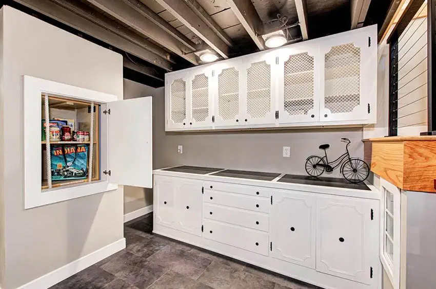Basement pantry with manual dumbwaiter and white cabinets