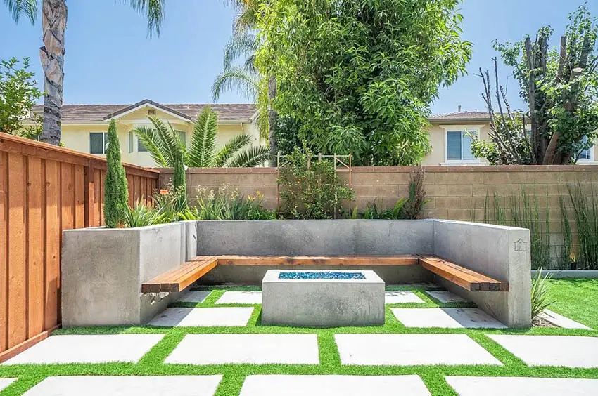 Concrete patio with bench fire pit and artificial grass