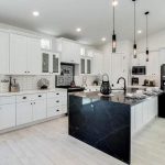 Contemporary kitchen with black quartz countertop island, white quartz and white cabinets