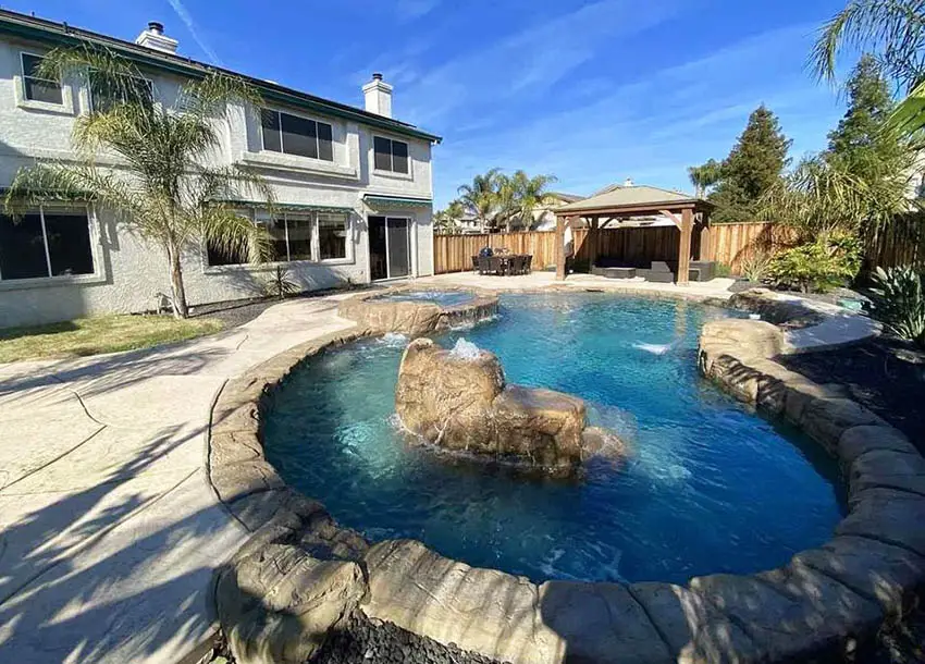 Custom lazy river pool with rock water feature hot tub