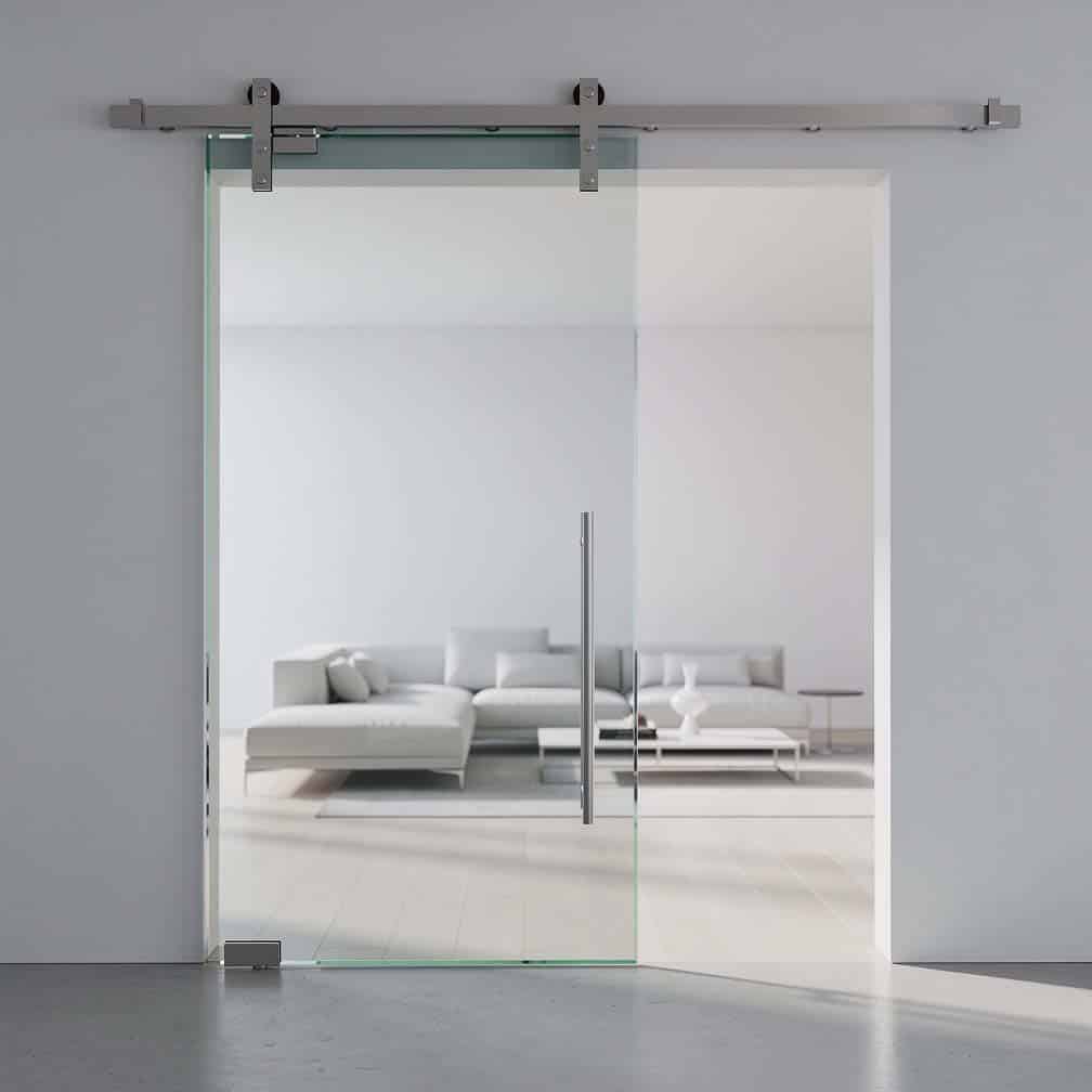 Frameless tempered glass sliding door on brushed stainless steel hardware with a soft-close damper in a minimalist interior