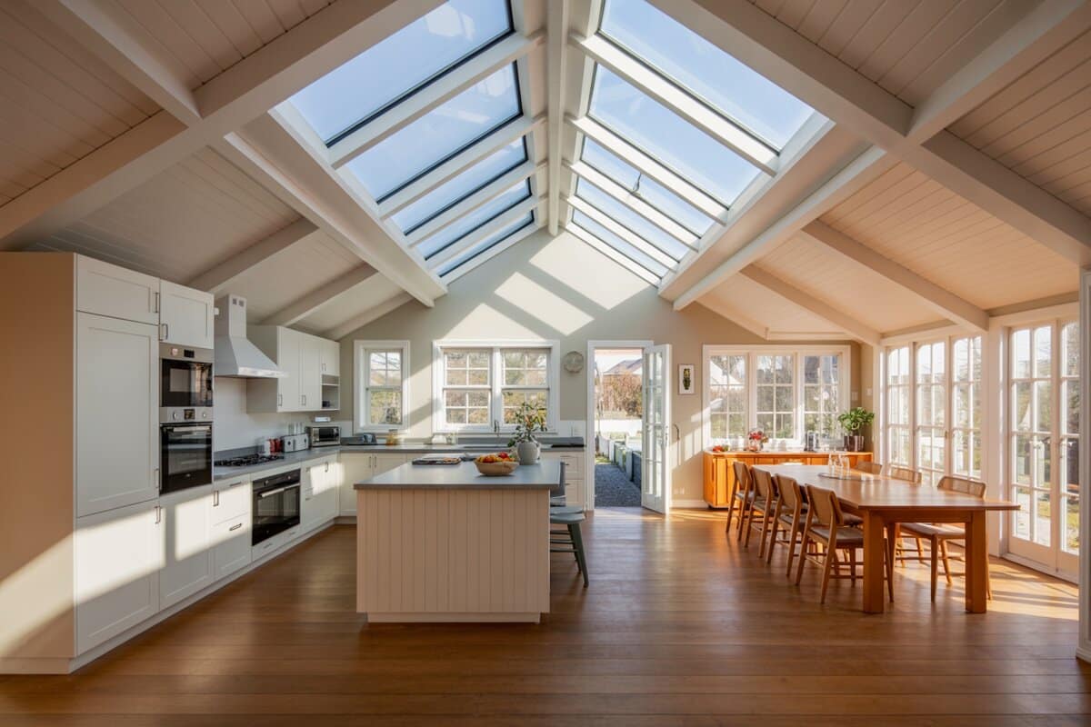 Open plan kitchen and dining room beneath a vaulted skylight ceiling