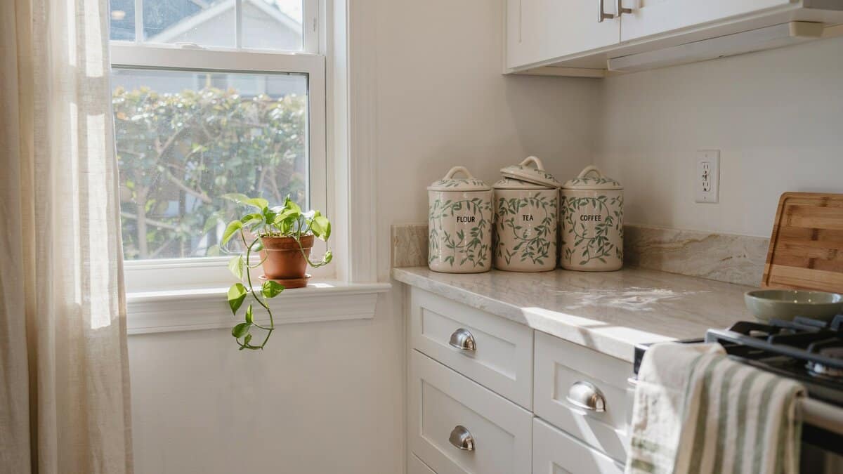 Matching decorative ceramic storage containers styled on a kitchen corner window counter