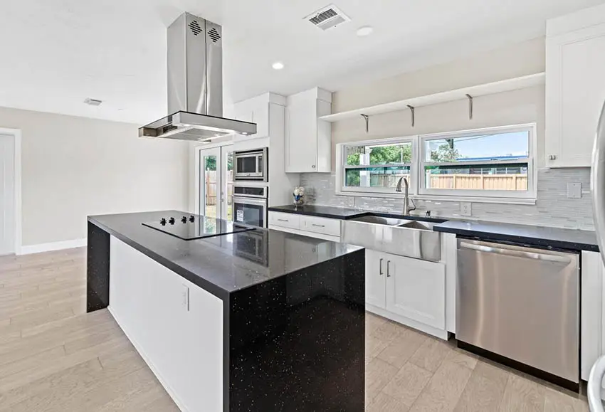 Kitchen with glossy black quartz countertops white cabinets